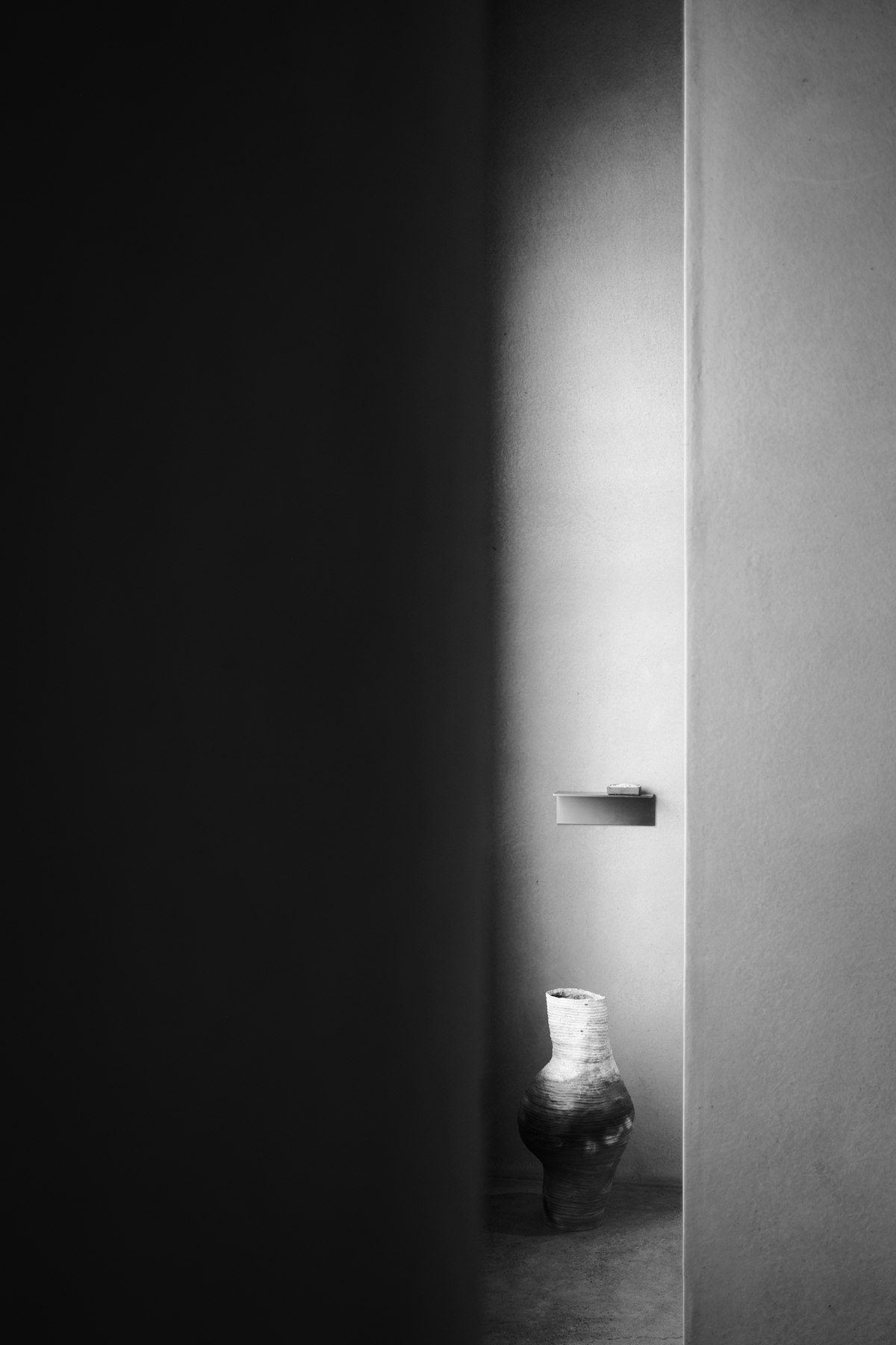 Vase en céramique dans une niche de lumière, clair-obscur